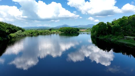 Irlanda-Lugares-épicos-Drones-Volando-Por-El-Río-Blackwater-En-Waterford-En-Un-Tranquilo-Día-De-Verano-Aguas-Suaves-Y-Nubes-Hinchadas-En-Un-Cielo-Azul