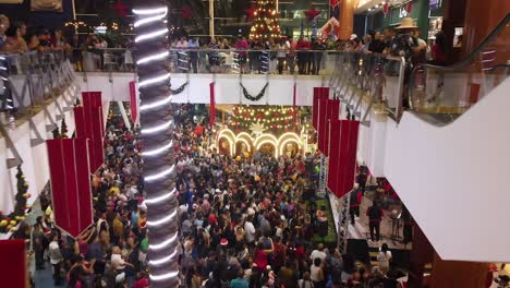 Aerial-of-illuminated-Christmas-tree-and-a-crowd-in-La-Vela-Shopping-Mall,-Isla-de-Margarita,-during-holidays