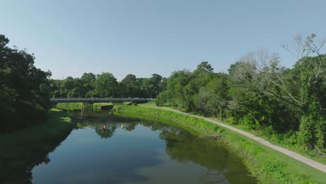 Eine-Luftaufnahme-Per-Drohne-Von-Zwei-Kajakfahrern,-Die-Unter-Blauem-Himmel-In-Houston,-Texas,-Den-Horsepen-Bayou-Hinaufpaddeln