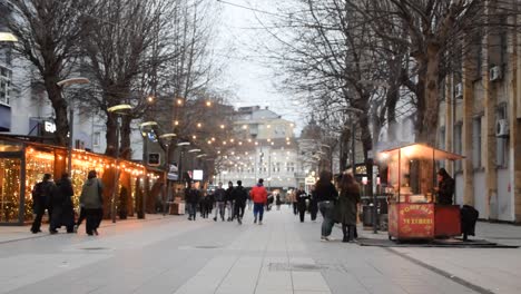 People-walking-in-the-pedestrian-zone-in-Albanian-side-of-Mitrovica,-Kosovo