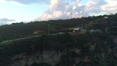 Toma-Aérea-De-Un-Porsche-Cayman-En-Movimiento-En-Las-Carreteras-Colombianas-Durante-Una-Tarde-Soleada