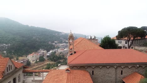 dolly-in-shot-of-a-Church-Dome-during-day-above-the-rooftop-bricks-of-a-mosque-in-Lebanon