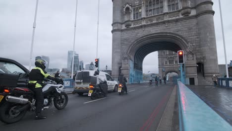 Wide-shot-of-tower-bridge-London-traffic-gates-opening-on-a-rainy-cloudy-day