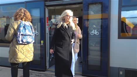 Eine-Gruppe-Kaukasischer-Passagiere,-Die-Während-Der-Hauptverkehrszeit-Mit-öffentlichen-Verkehrsmitteln-Auf-Dem-Bahnsteig-Aus-Dem-Zug-Steigen---Stabile-Handaufnahme