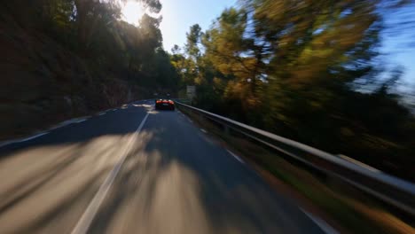 Impresionante-Antena-Fpv-Siguiendo-Un-Lamborghini-Verde-Viajando-Por-Una-Carretera-Rural-En-Las-Colinas-De-Cataluña,-España