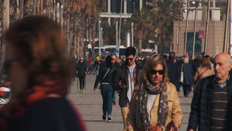 Guy-in-sunglasses-walks-on-the-boulevard-in-Barcelona-with-a-lot-of-people-around-him---Zoomed-shot