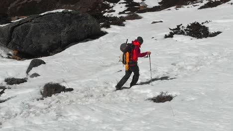 A-solo-trekker-trekking-through-a-snow-trail-in-a-sloppy-hill