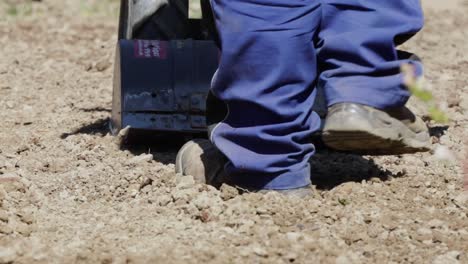 Farmer-man-driving-small-hand-tractor-for-soil-cultivation-in-slow-motion