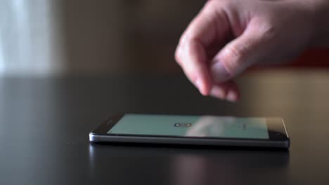 Close-up-male-hand-using-smartphone-scrolling-through-Instagram