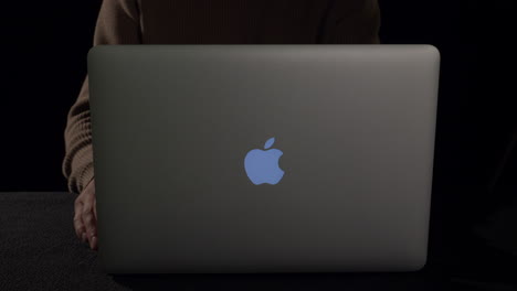 Guy-sits-down-at-Laptop-and-start-working,-static-low-key-shot