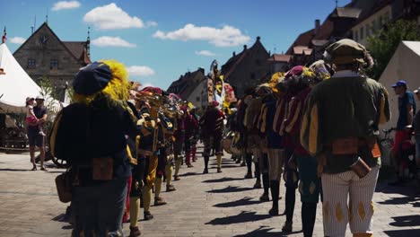 A-number-of-individuals-may-be-seen-in-a-video-waving-the-flags-of-Neuburg-a-der-Donau-and-Palatinate-Neuburg-at-the-Wallenstein-Festspiele-in-Altdorf,-Bavaria