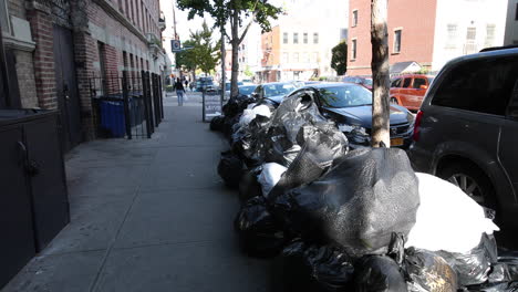 Trash-bags-on-footpath-on-street-in-Brooklyn,-NY