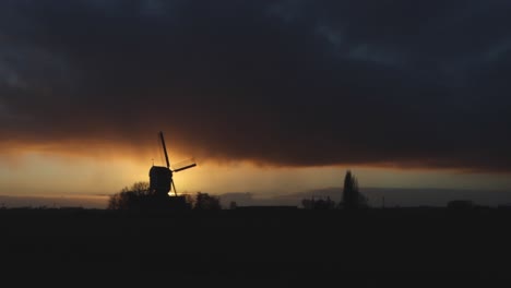 Silhouette-Einer-Alten-Windmühle-In-Den-Niederlanden-Bei-Sonnenuntergang-An-Einem-Stürmischen-Tag