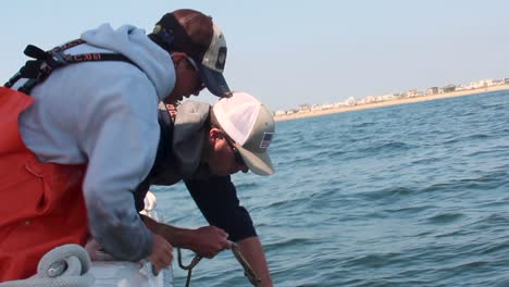 Dos-Pescadores-De-Langosta-Sacan-Una-Trampa-Para-Langostas-Verde-De-Un-Mar-Agitado-En-Un-Barco