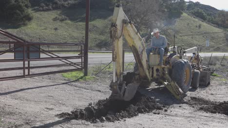 Tractor-Retroexcavadora-Desenterrando-La-Línea-De-Agua.