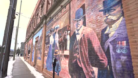 Walking-down-the-sidewalk-of-downtown-Collingwood-in-winter-with-graffiti-on-the-wall