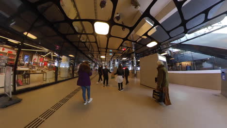 People-Walking-At-The-Corridor-In-Amsterdam-Central-Railway-Station-In-Amsterdam,-Netherlands---low-angle,-wide-shot