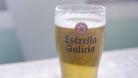 4k-bright-moving-shot-of-spanish-draft-beer,-Estrella-Galicia