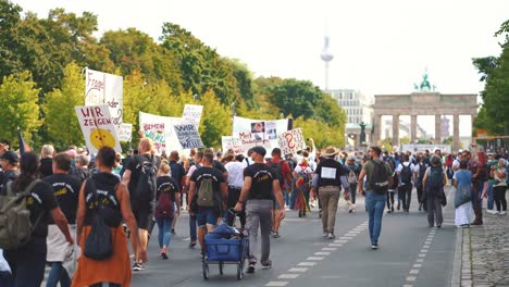 Manifestantes-En-Una-Manifestación-De-Corona-Covid-19-Contra-La-Decisión-De-Usar-Máscaras-Faciales-Contra-La-Pandemia-En-Berlín,-La-Capital-Reunificada-De-Alemania,-Sosteniendo-Carteles-Y-Acercándose-A-La-Puerta-De-Brandenburgo