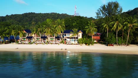 Wake-up-to-gentle-waves,-golden-light,-and-palm-trees-swaying-on-a-tropical-beach