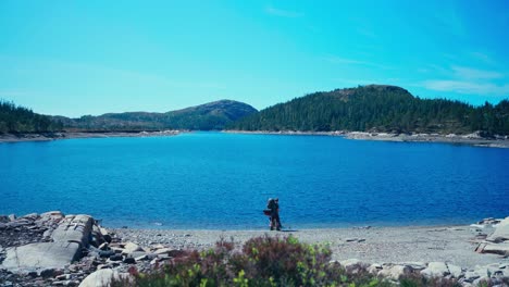 Excursionista-Con-Perro-Cerca-Del-Tranquilo-Lago-Azul-Sobre-Rutas-De-Senderismo-De-Montaña