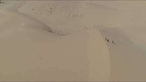 Volando-Desde-El-Cielo-A-Cuatro-Viajeros-En-La-Cima-Del-Desierto-De-Dunas-De-Arena-Blanca-Explorando-La-Naturaleza-Perdida-En-Ningún-Lugar-Vacío-En-Mui-Ne-Vietnam