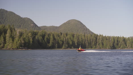 A-boat-going-fast-on-the-ocean-around-Vancouver-Island,-Tofino,-British-Columbia,-Canada