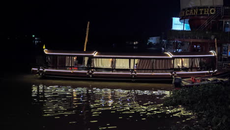 Illuminated-tourist-boat-with-neon-lights-in-the-harbour-at-night