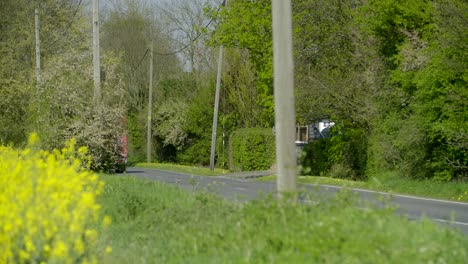 Red-luton-van-drives-down-a-country-road-following-by-a-white-van