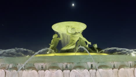 Triton-Wasserbrunnen-Skulptur-In-Der-Nacht-Mit-Dem-Mond-Darüber-Gesehen