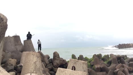 Dos-Pescadores-Haciendo-Pesca-En-Roca-Desde-Las-Barreras-De-Olas.