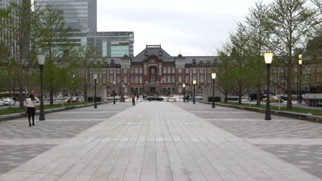 Walking-towards-cross-traffic-and-the-public-entrance-of-the-main-train-station-Tokyo-Station,-Japan,-hyper-lapse