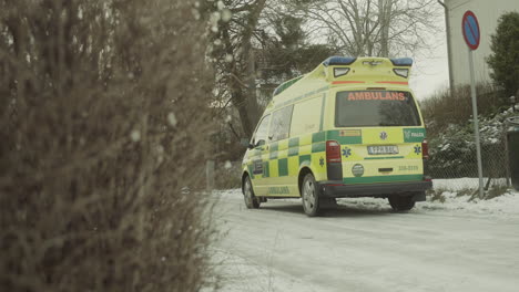 Handheld-Video-Einer-Winterlichen-Vorstadtstraße,-Notarztwagen-In-Stockholm