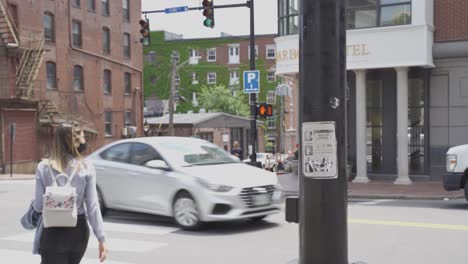 Pedestrian-woman-wearing-black-face-mask-pressing-button-and-crossing-street