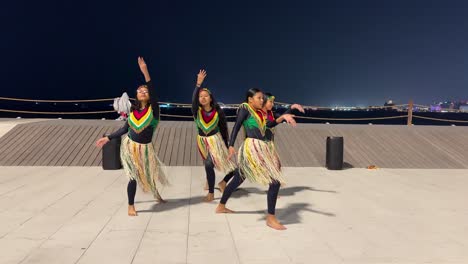 Qatar-Doha-beach-and-Kenyan-teenager-young-girl-are-dancing-with-music-in-harmony-way-of-performance-together-happy-and-cheerful-African-women-move-group-colorful-clothes-fashion-long-hair-at-night