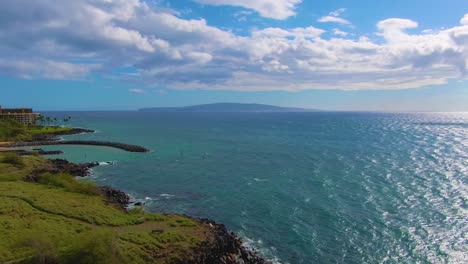 Flying-low-along-the-coast-of-Kihei,-Hawaii-on-a-sunny-day