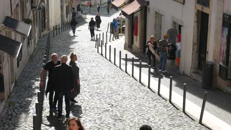 Gente-Caminando-Por-El-Camino-Adoquinado-En-El-Casco-Antiguo-De-Lisboa,-Portugal