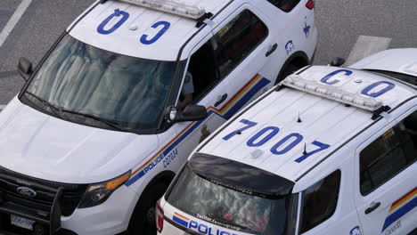 Top-shot-of-police-officer-chatting-with-people-beside-police-car-with-4k-resolution