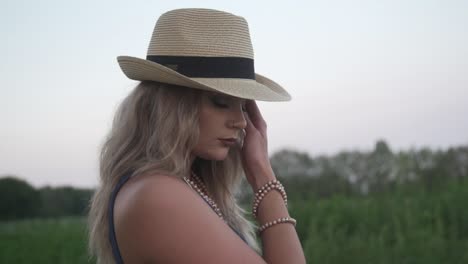 A-Model-Strikes-A-Pose-In-The-Green-Field-Of-Grass-Background-With-Trees-And-Bright-Sky-In-Ontario,-Canada---Close-Up-Shot