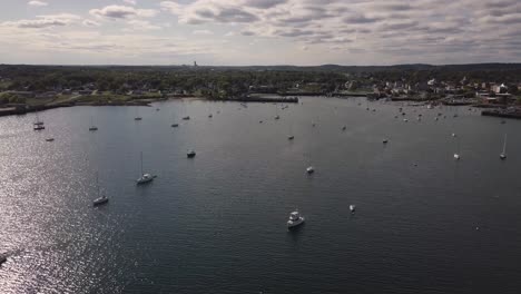 Aerial-Drone-Shot-Flying-Over-Sailboats-In-Rockland-Harbor-In-Maine-Toward-Land