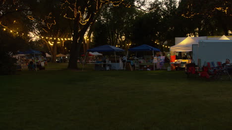 Eine-Weitwinkelaufnahme-Einer-Lokalen-Geschäftsmesse-Und-Eines-Bauernmarkts-Im-Kleinen-Stadtpark-Am-Abend