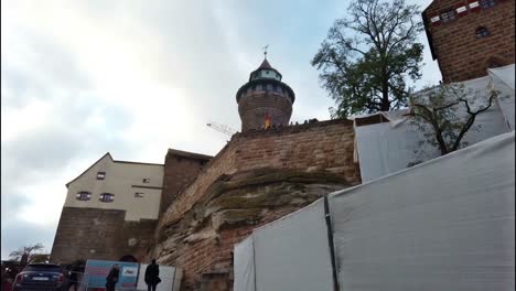 Slow-walk-below-the-Kaiserburg-in-Nuremberg-with-camera-tracking-of-its-main-tower