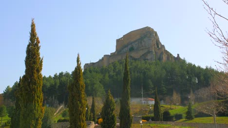 Fachada-Trasera-De-Las-Ruinas-Del-Castillo-De-Morella-En-La-Cima-De-Una-Colina-Con-La-Ladera-Cubierta-De-árboles-En-Castellón,-España---Gran-Angular