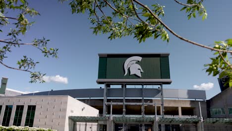 Exterior-of-Spartan-Stadium-on-the-campus-of-Michigan-State-University-in-East-Lansing,-Michigan-pan-left-to-right-with-trees