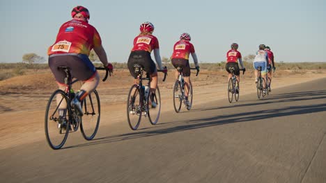 Tracking-behind-a-group-of-cyclists-on-a-competition,-wide-shot