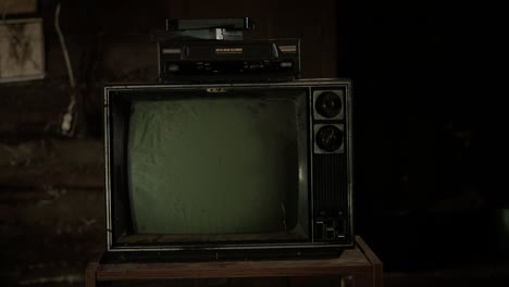 Slow-zoom-in-on-an-old,-dirty-tv-and-vcr-in-a-cabin