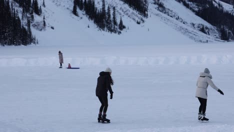 Zeitlupe:-Folgen-Sie-Jungen-Mädchen-Beim-Schlittschuhlaufen-Auf-Dem-Eis,-Winterlandschaft,-Lake-Louise