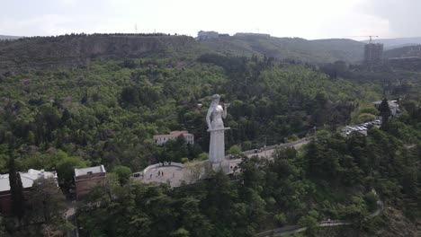 Toma-Aérea-De-La-Madre-De-Georgia-Tbilisi-Georgia-Centro-De-La-Ciudad-Puente-De-La-Paz-Iglesia-Samiba-Río-Casas-Antiguas