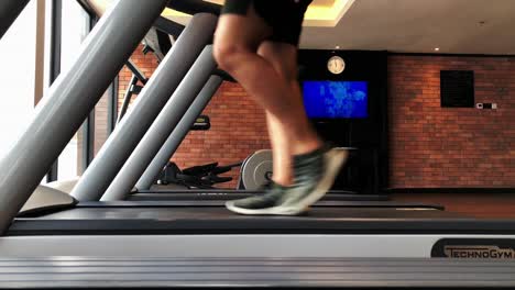 Asian-man-jogging-on-treadmill,-accelerating-from-jogging-to-running