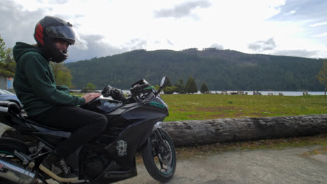 Motociclista-Con-Casco-Sentado-En-Motocicleta-En-Un-Parque-Al-Aire-Libre,-Pasión-Por-Los-Deportes-De-Motor-Y-Aventura